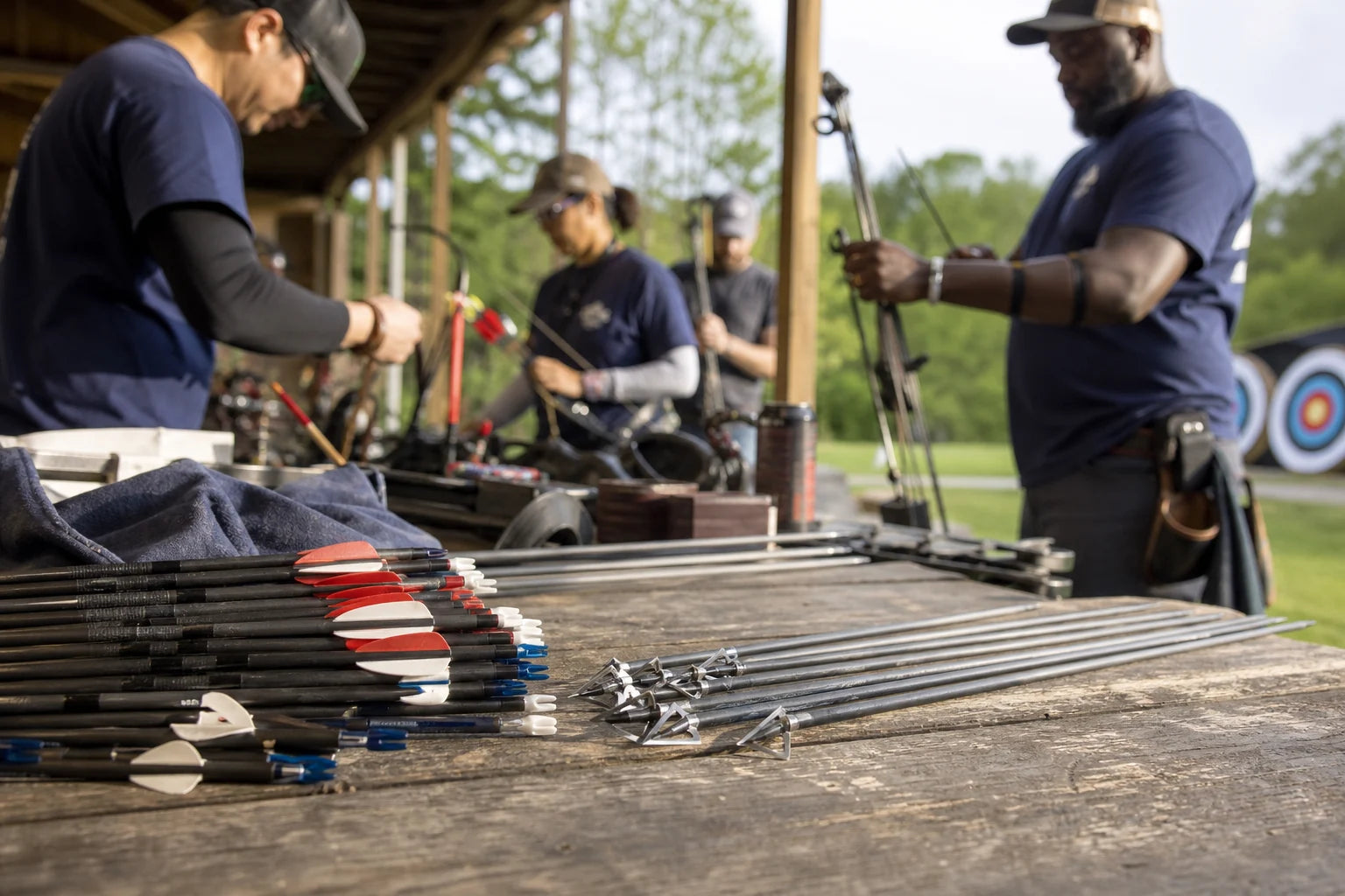 Archers preparing equipment together at an outdoor range
